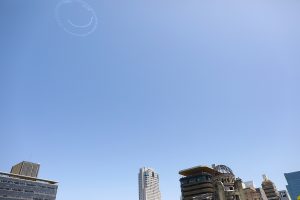 原爆ドーム上空にニコちゃんマークが描かれる「Fly for ALL #大空を見上げよう」